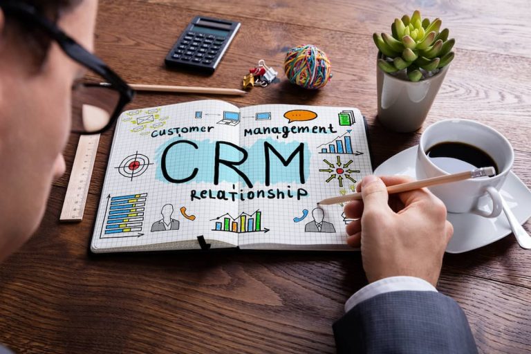 Empresario dibuja la palabra CRM en un cuaderno