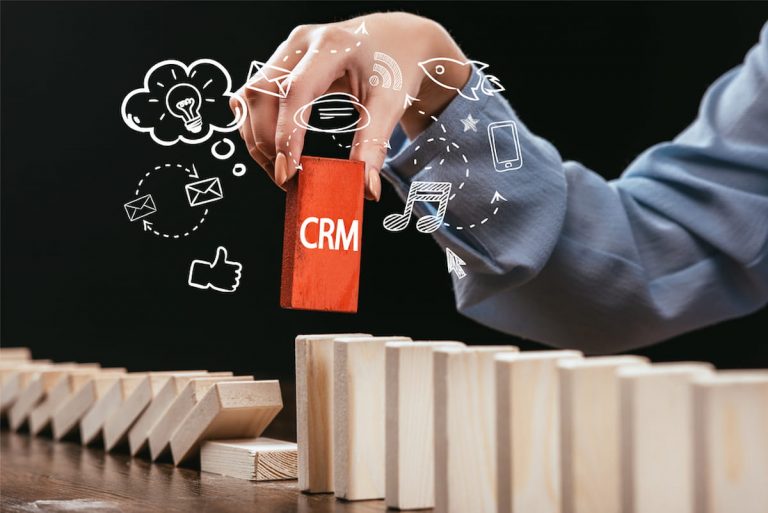 Vista recortada de la mujer recogiendo bloque rojo con la palabra 'crm'